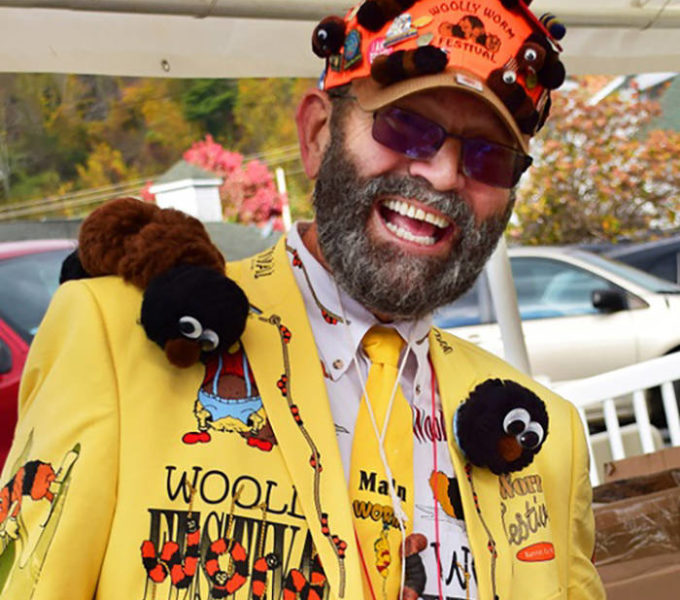 A man at the Woolly Worm Festival wears colorful clothing decorated with fuzzy, fake worms.