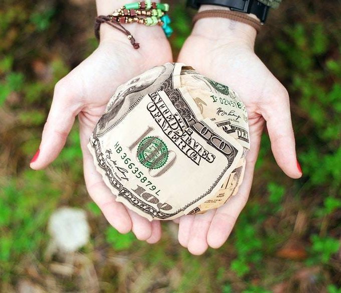 A woman's hands are holding money for donations